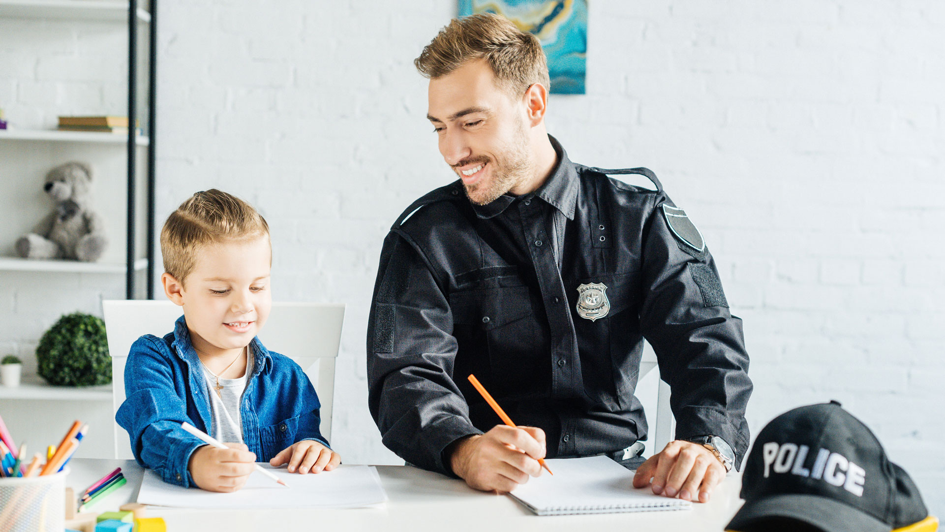 Student and police officer smiling and sitting at table